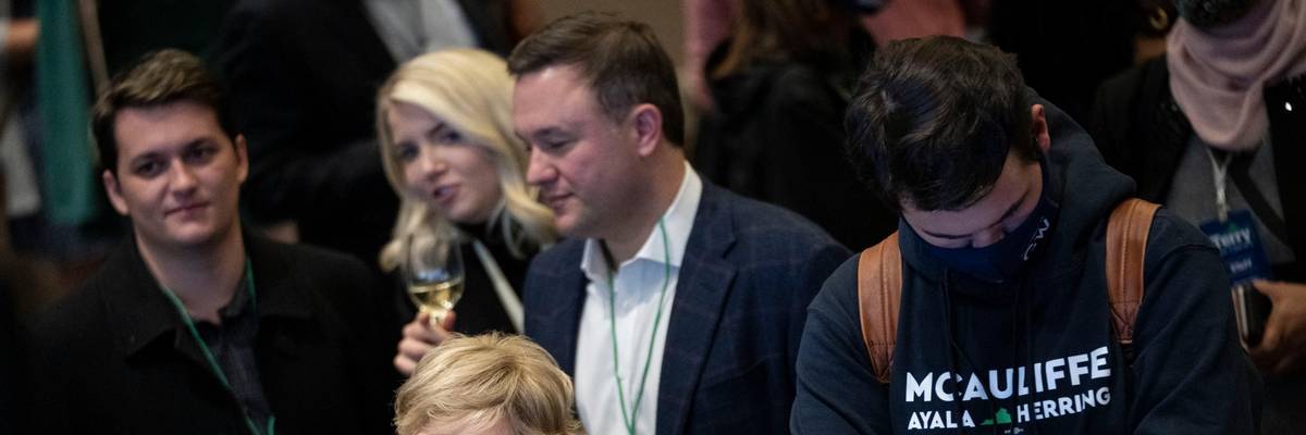 Supporters of Terry McAuliffe look on