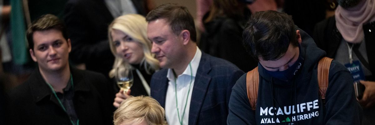 Supporters of Terry McAuliffe look on