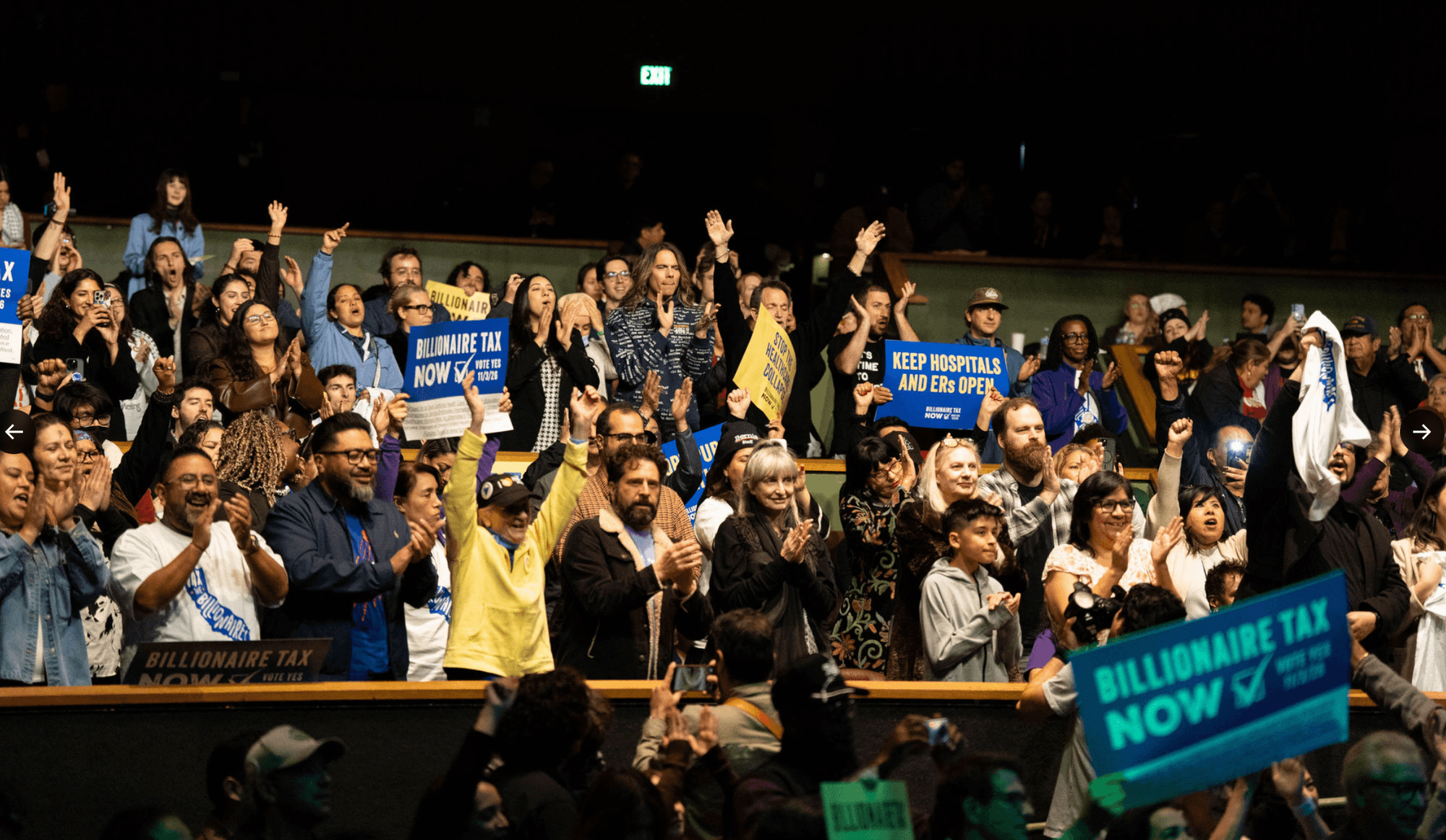 supporters of the California Billionaire Tax applaud in an auditorium