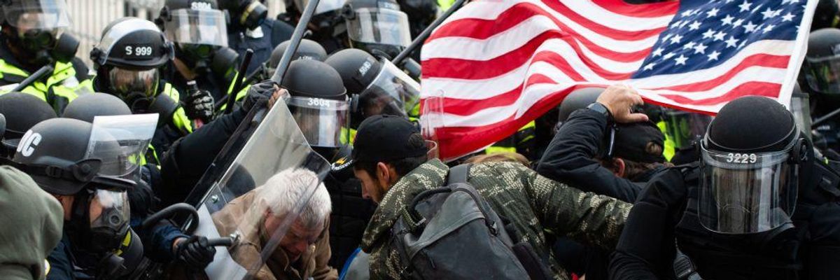 Supporters of U.S. President Donald Trump fight with riot police outside the U.S. Capitol.