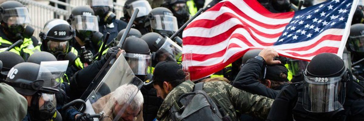 Supporters of U.S. President Donald Trump fight with riot police outside the U.S. Capitol.