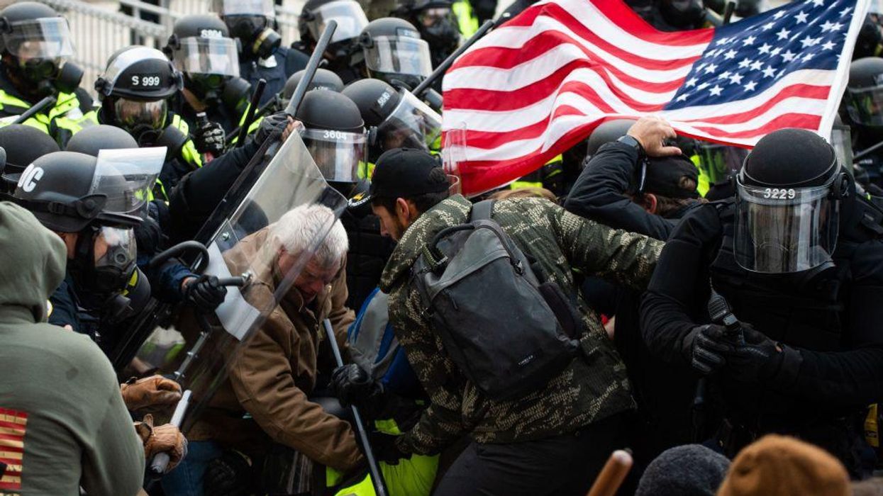Supporters of U.S. President Donald Trump fight with riot police outside the U.S. Capitol.