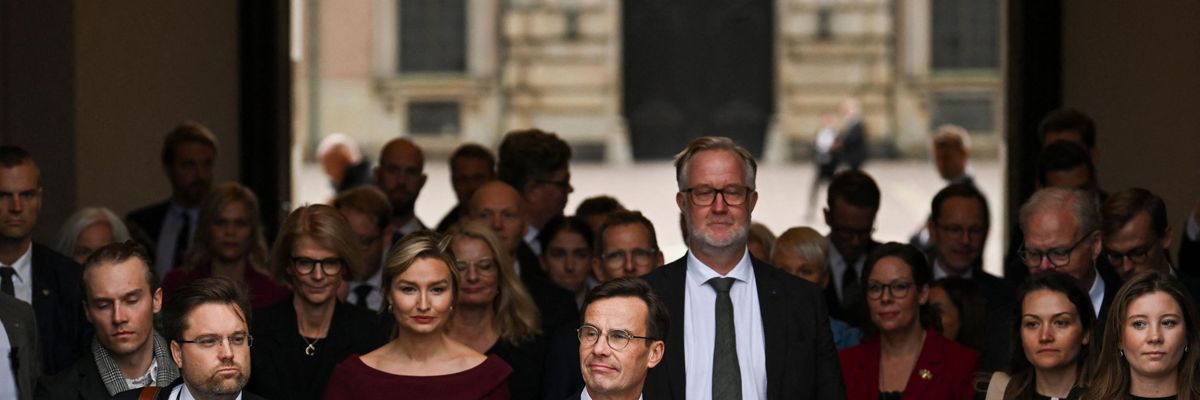 Sweden's right-wing prime minister walks with members of the new government