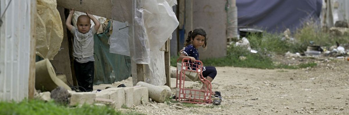 Syrian children play outside their family's tent