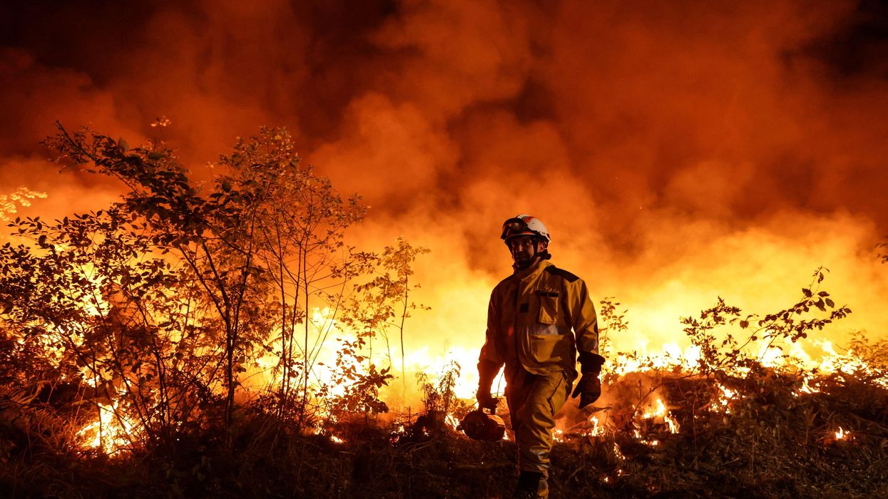 Tactical firefighters work to prevent a wildfire from spreading further as the winds change in Louchats, France on July 17, 2022.