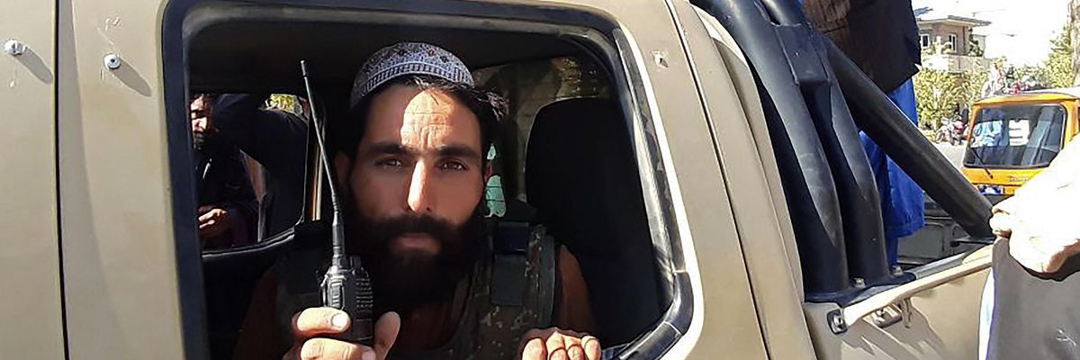 Taliban fighters in a vehicle along the roadside in Herat