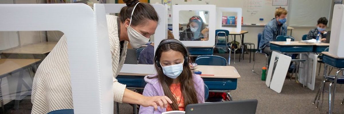 Teacher and student work on computer.