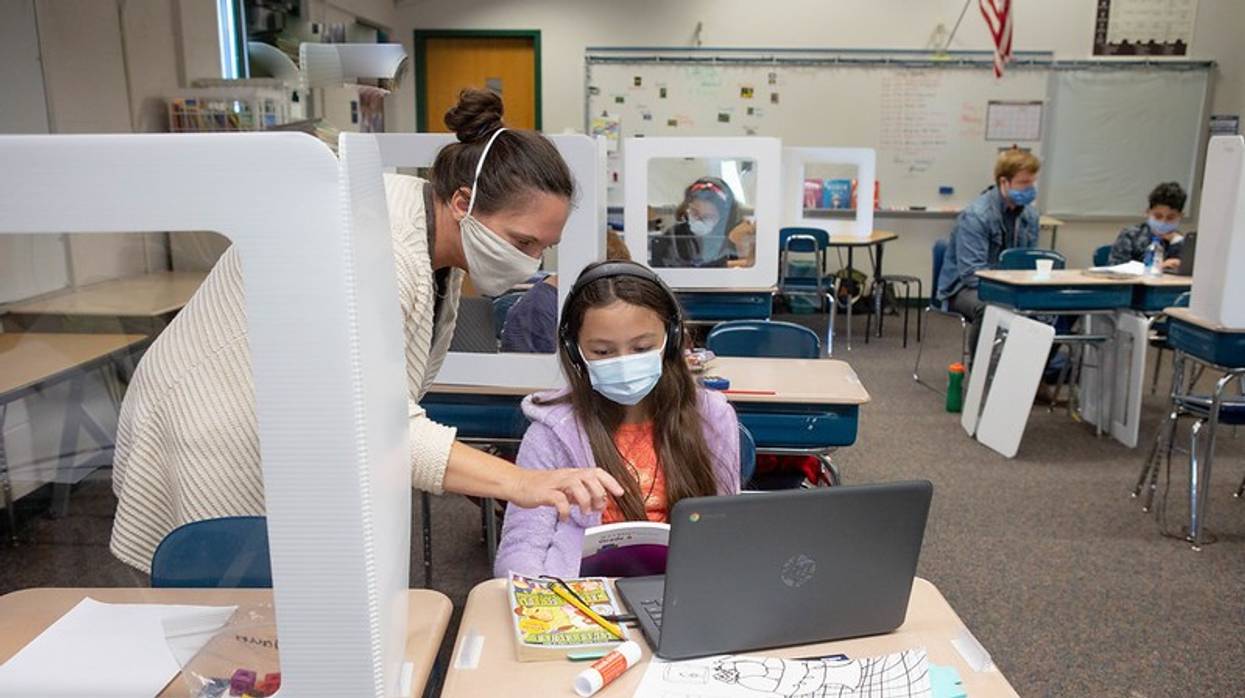 Teacher and student work on computer.