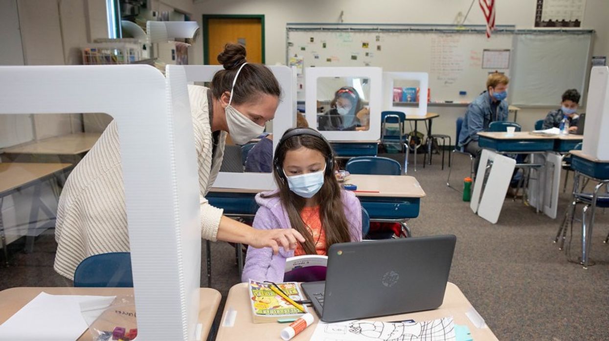 Teacher and student work on computer.