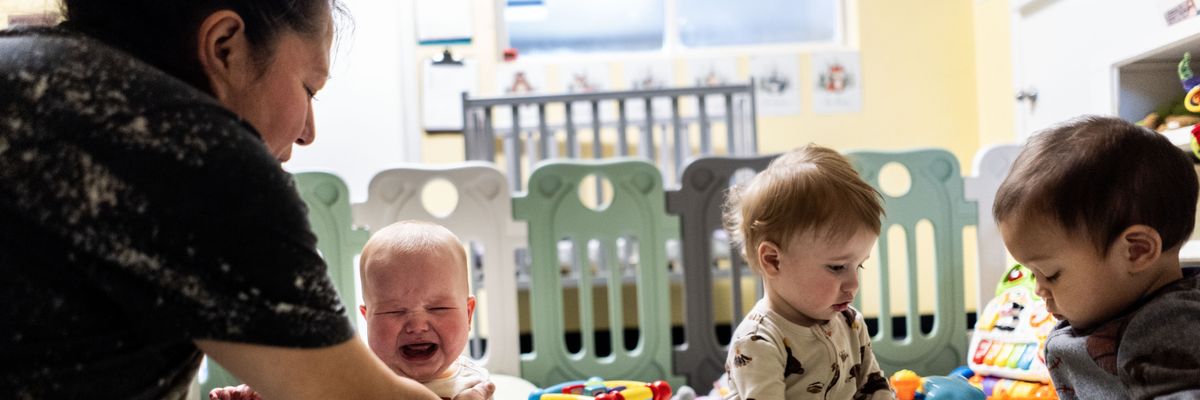 Teacher Monica Benavides comforts a young child in the infant room at TLC for Tots daycare center