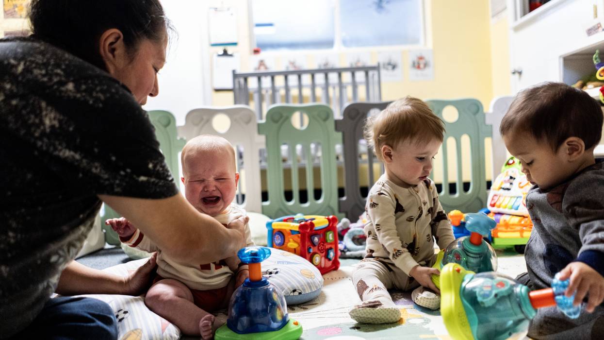 Teacher Monica Benavides comforts a young child in the infant room at TLC for Tots daycare center