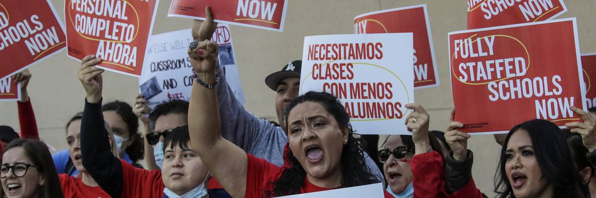 Teachers union members holding signs that read "We Need Smaller Class Sizes" and "Fully Staffed Schools Now"