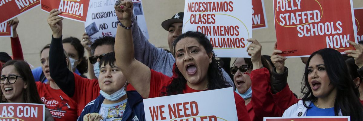 Teachers union members holding signs that read "We Need Smaller Class Sizes" and "Fully Staffed Schools Now"