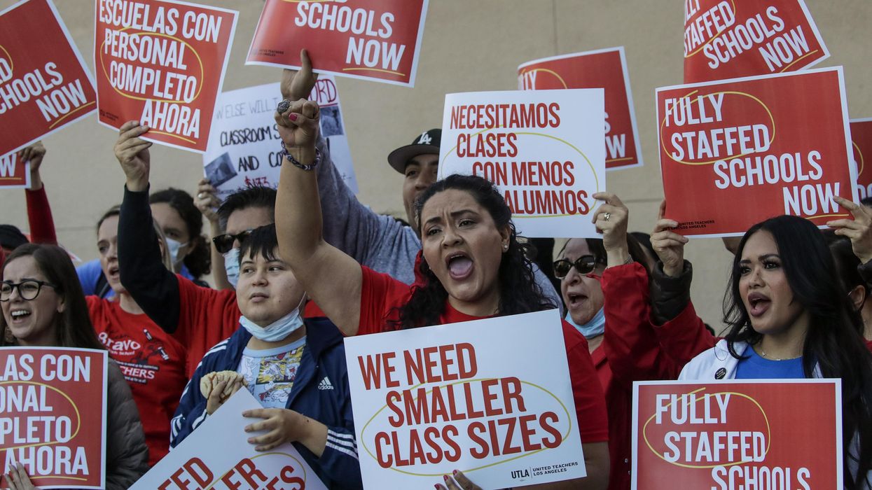 Teachers union members holding signs that read "We Need Smaller Class Sizes" and "Fully Staffed Schools Now"