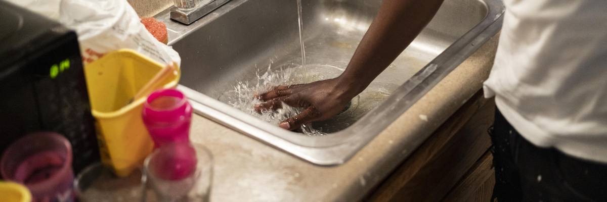 Terrence Carter mixes bleach and soap with water before washing dishes on September 1, 2022 in Jackson, Mississippi.