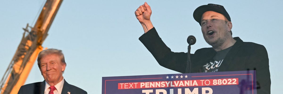 Tesla CEO Elon Musk (R) speaks on stage as he joins Donald Trump