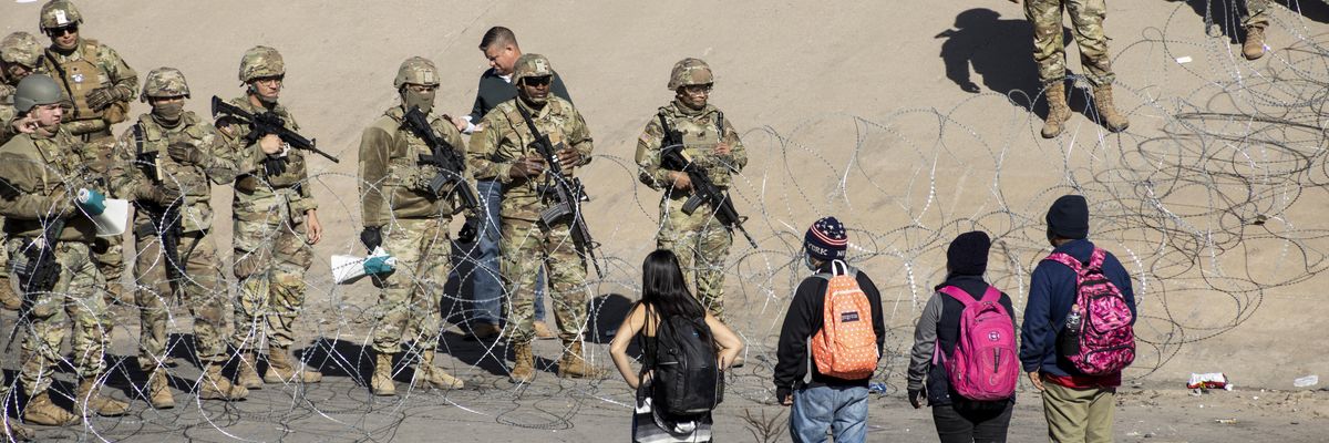 Texas National Guard members stand next to a razor wire fence in El Paso to prevent Latin American migrants waiting in Ciudad Juarez from entering the United States on December 21, 2022