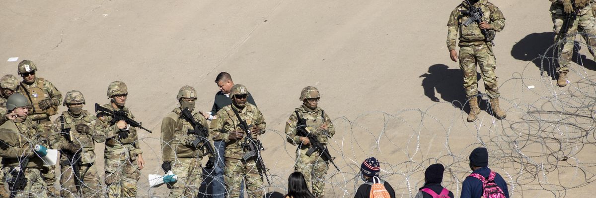 Texas National Guard members stand next to a razor wire fence in El Paso to prevent Latin American migrants waiting in Ciudad Juarez from entering the United States on December 21, 2022