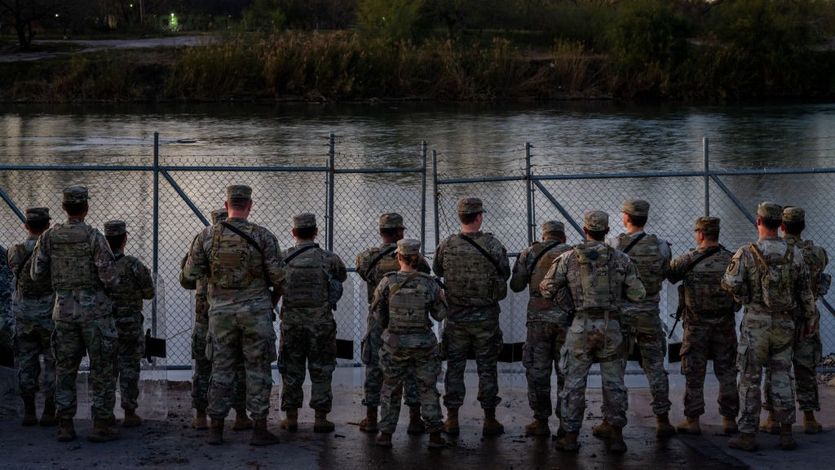 Texas National Guard soldiers stand guard on the banks of the Rio Grande