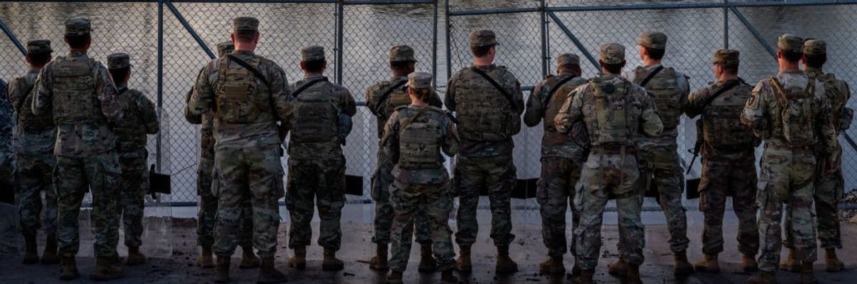 Texas National Guard soldiers stand guard on the banks of the Rio Grande
