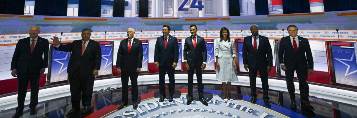 The 2023 Republican primary candidates stand on stage before a debate. 
