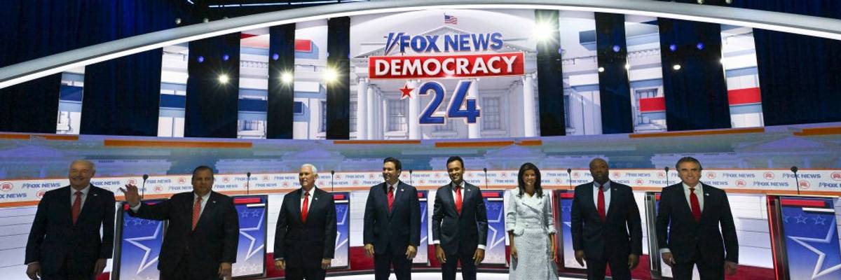 The 2023 Republican primary candidates stand on stage before a debate.