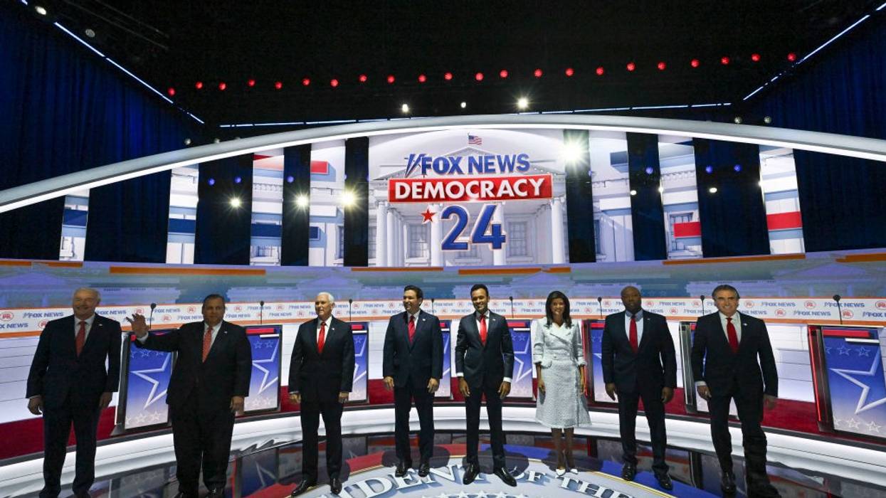 The 2023 Republican primary candidates stand on stage before a debate.
