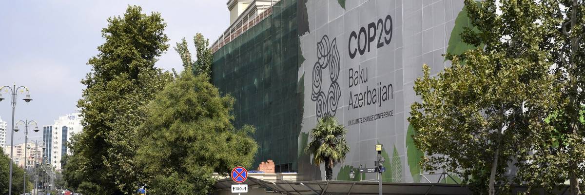 The logo of the COP29 climate conference appears on the facade of a building.