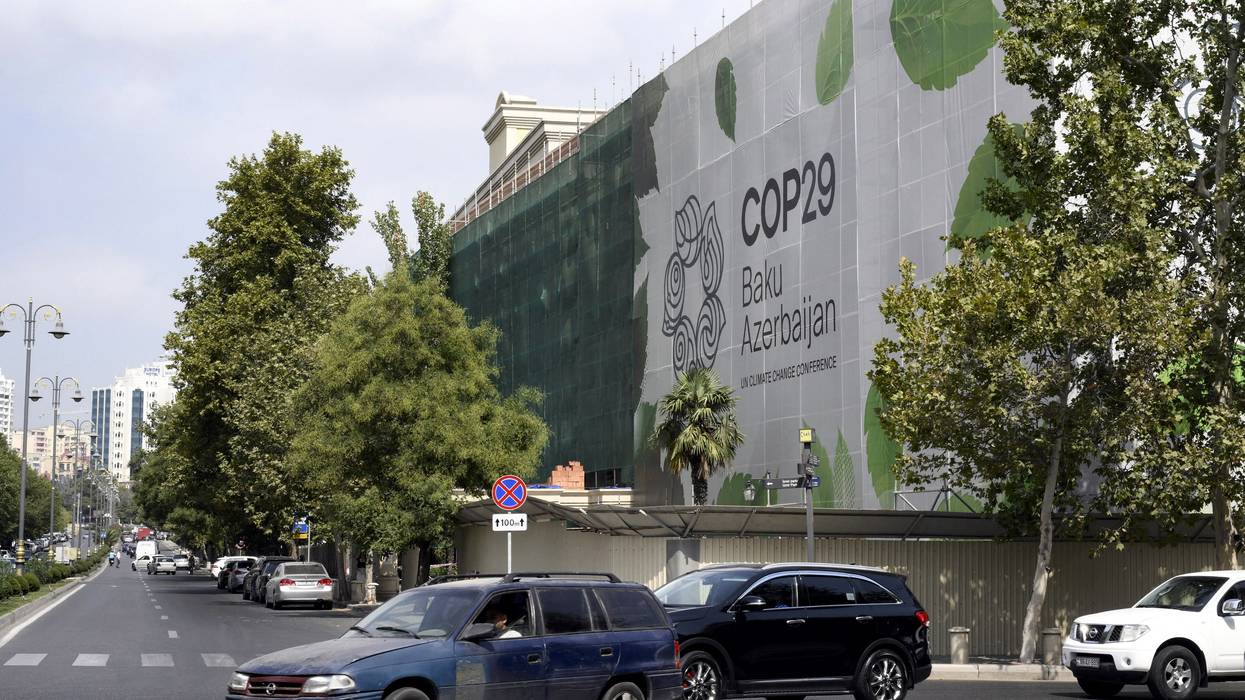 The logo of the COP29 climate conference appears on the facade of a building.