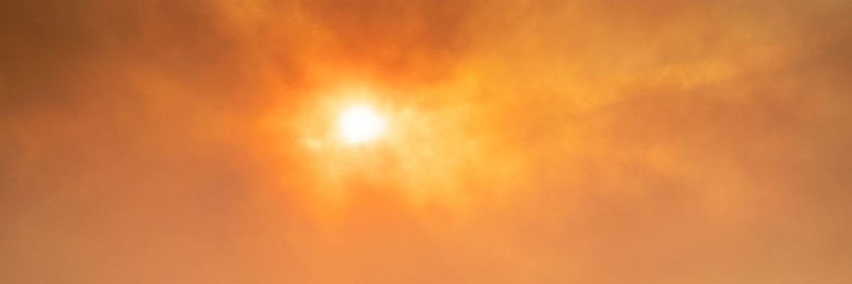 The sun shines orange through wildfire smoke.