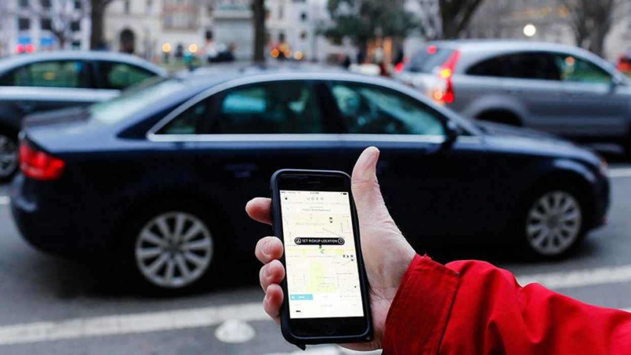 The Uber phone app is shown as cars drive by in Washington, D.C.