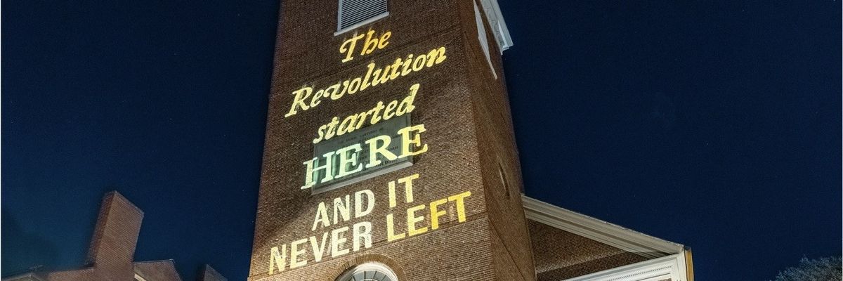 The words "The Revolution started here and it never left" are projected on Boston's Old North Church.