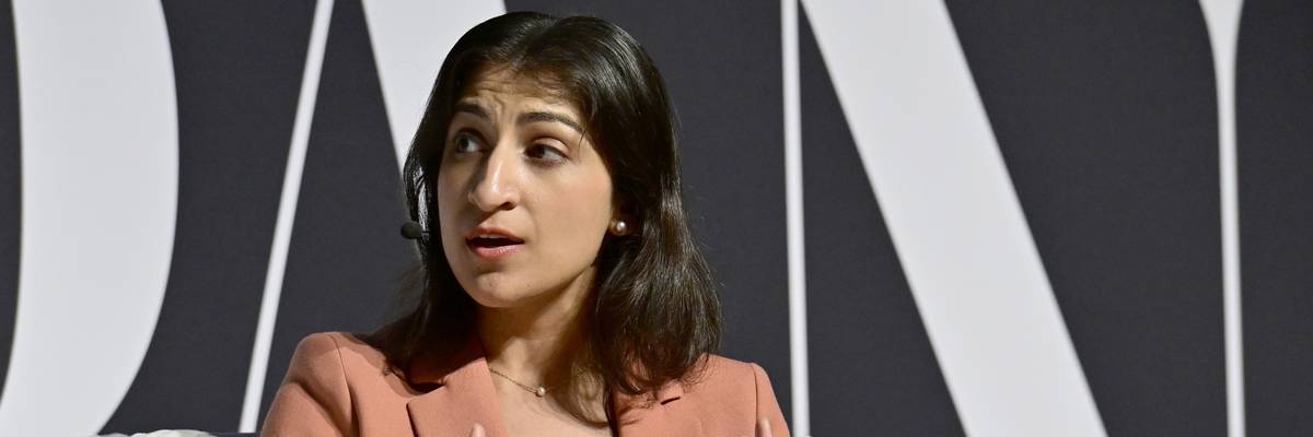 Then-Federal Trade Commission Chair Lina Khan in a pink suit sitting in a chair