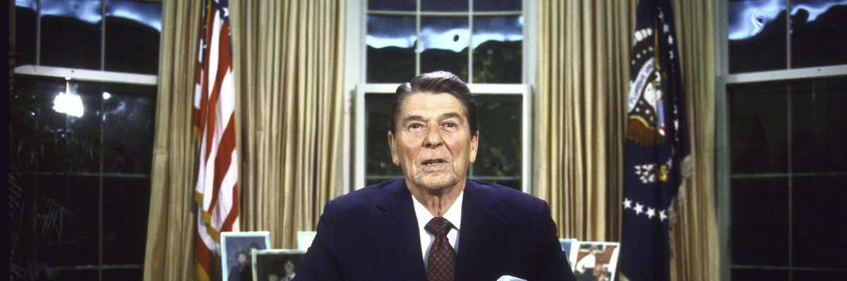 Then-President Ronald Reagan seated at his desk in the Oval Office