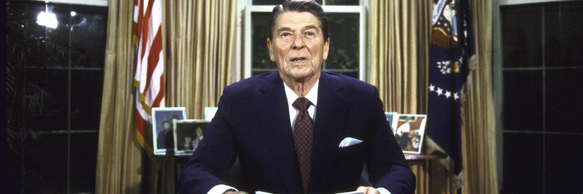 Then-President Ronald Reagan seated at his desk in the Oval Office