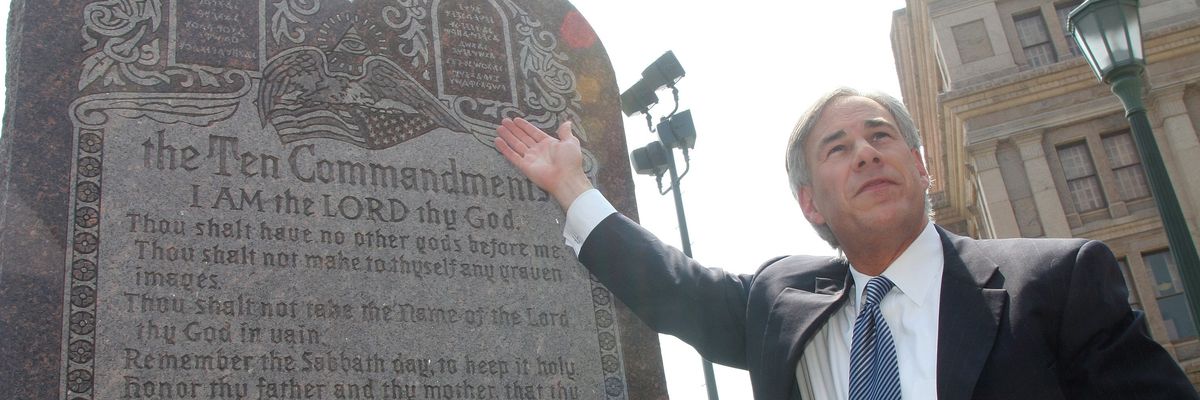 Then-Texas Attorney General Greg Abbott, now the state's governor, celebrates the U.S. Supreme Court decision that allows a Ten Commandments monument to stand outside the state capitol building in Austin on June 27, 2005.