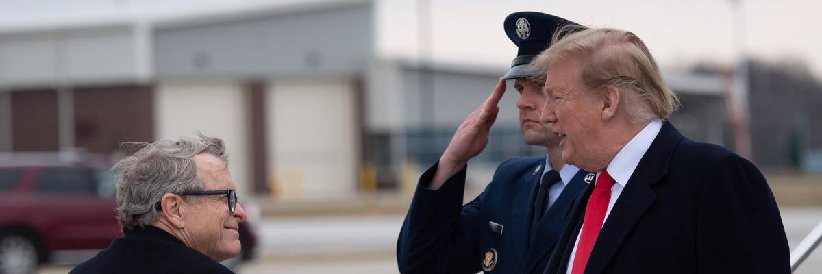 Then-U.S. President Donald Trump shakes hands with Ohio's Republican Gov. Mike DeWine as he disembarks from Air Force One at the Akron-Canton Airport in Canton, Ohio on March 20, 2019.