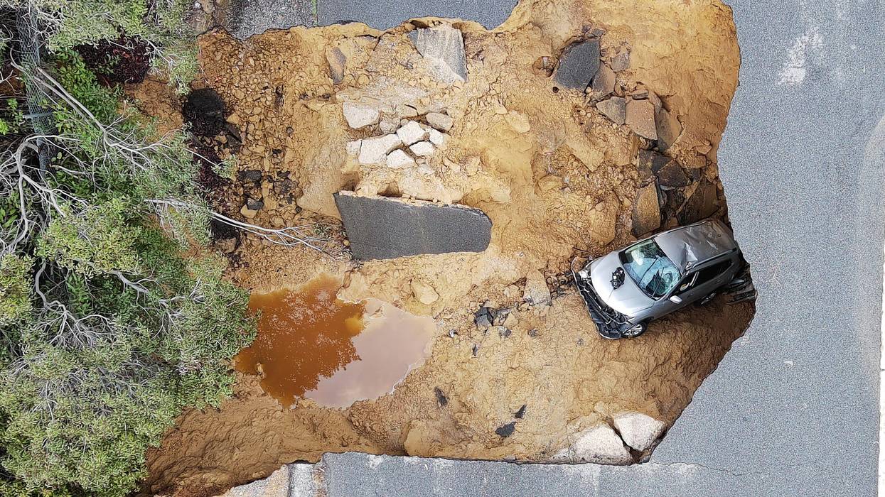 This aerial view shows cars that fell into a large sinkhole