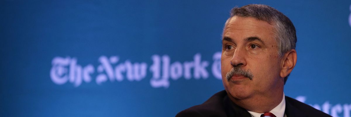 Thomas. Friedman in front of NYT logo.