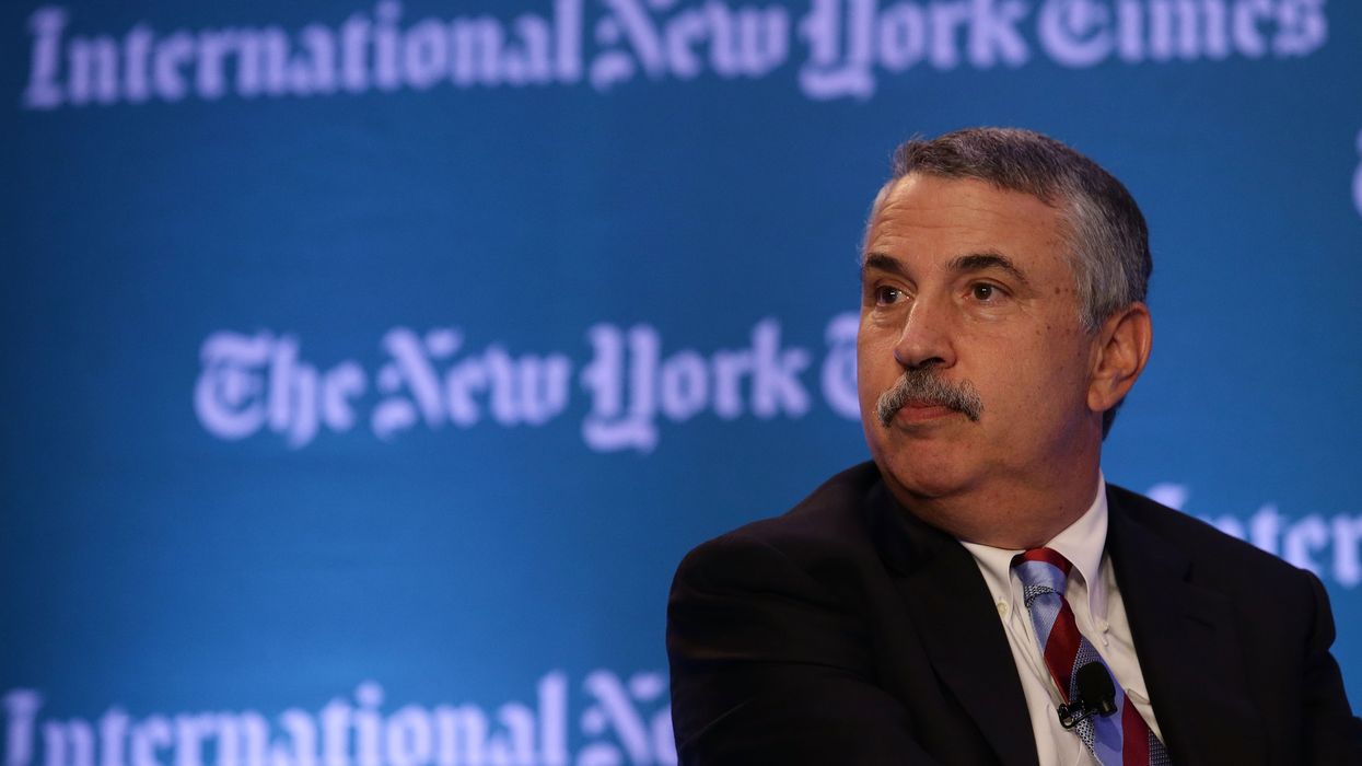 Thomas. Friedman in front of NYT logo.