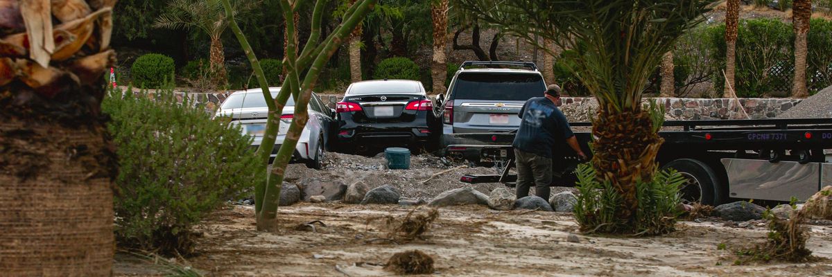 Three cars at the Inn at Death Valley pushed together by flash floods are towed on August 6, 2022.