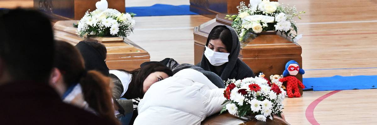 Three coffins sit on a gym floor.