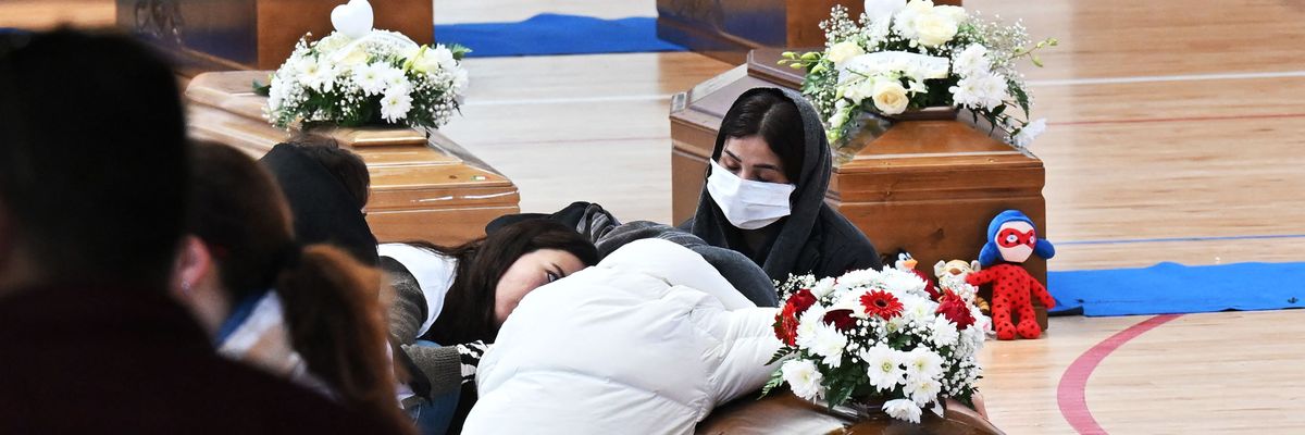 Three coffins sit on a gym floor.