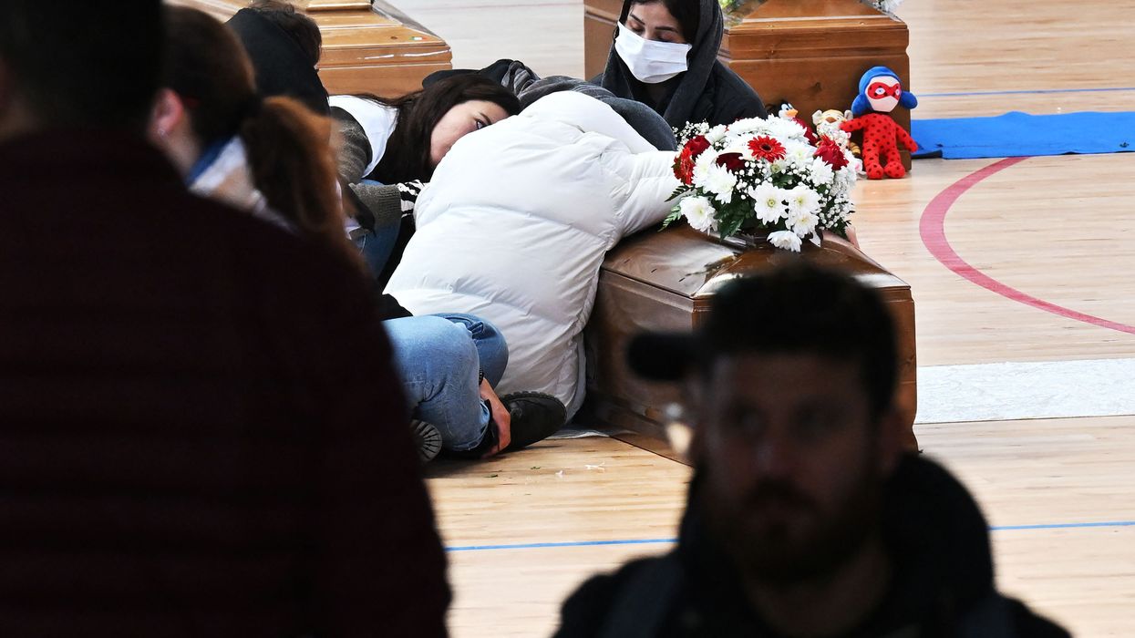 Three coffins sit on a gym floor.