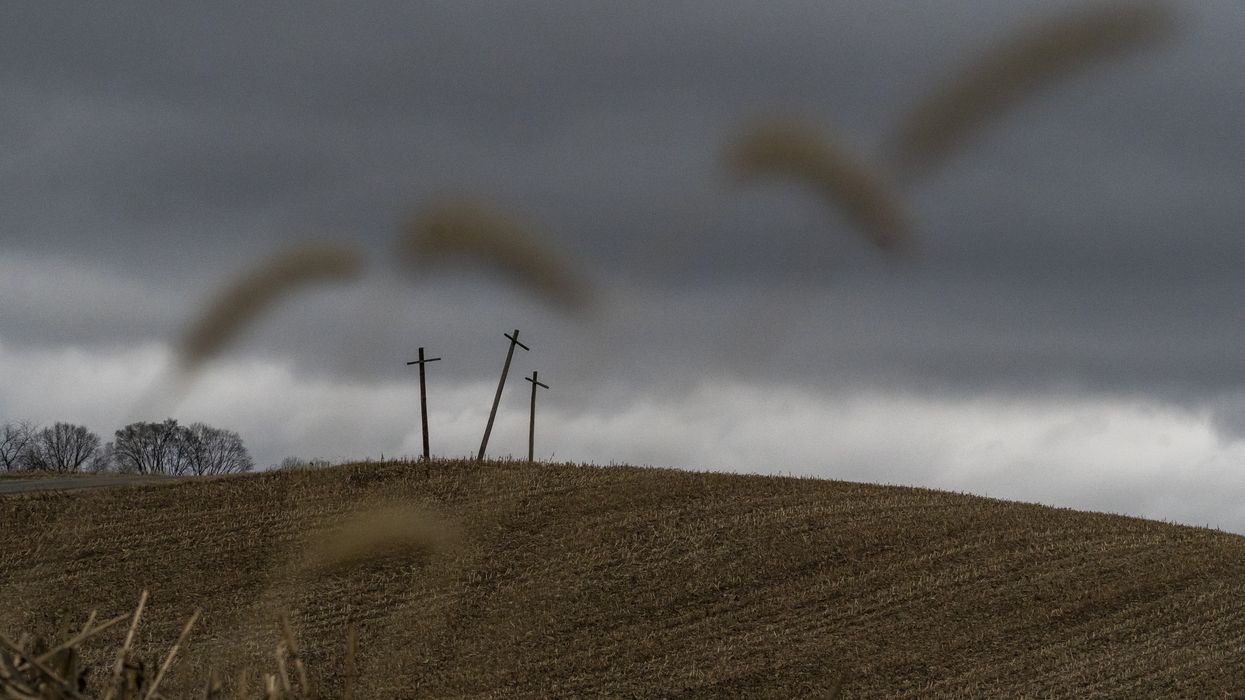 Three crosses stand on a hillside overlooking a farm on the state line of Ohio and Pennsylvania following a train derailment on February 17, 2023.