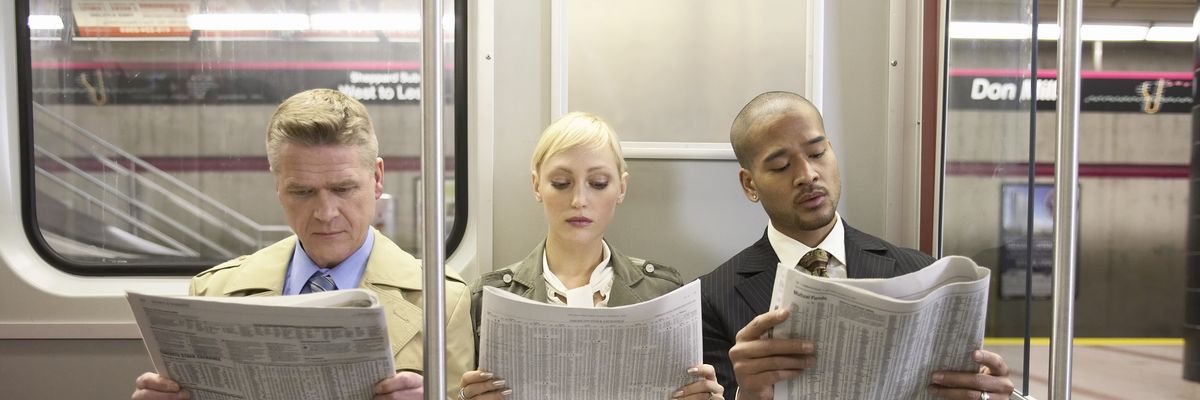 Three people on a subway train read newspapers. 