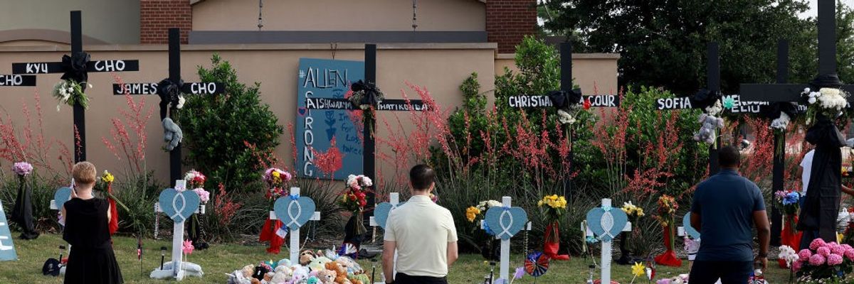 Three people stand in front of a memorial.