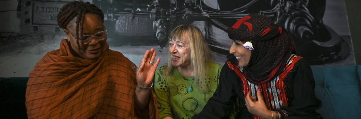 Three women laugh together.