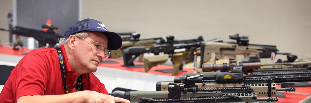 Timothy Schaefer inspects firearms at the Israel Weapon Industries booth to make sure they are not operational before the opening of the NRA Annual Meetings & Exhibits on April 13, 2023 in Indianapolis, Indiana.