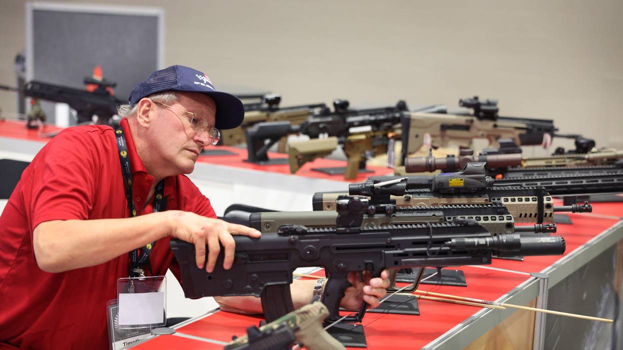 Timothy Schaefer inspects firearms at the Israel Weapon Industries booth to make sure they are not operational before the opening of the NRA Annual Meetings & Exhibits on April 13, 2023 in Indianapolis, Indiana.